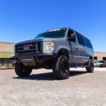Grey Ford Econoline van with WeldTec Designs 5-inch suspension lift kit