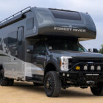 WeldTec Designs Sentinel front bumper installed on a Ford F-550/F-600 Forest River Super C RV with off-road tires, auxiliary LED lighting, and integrated winch.