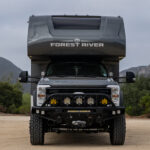 WeldTec Designs Sentinel front bumper installed on a Ford F-550/F-600 Forest River Super C RV with off-road tires, auxiliary LED lighting, and integrated winch.