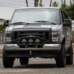 WeldTec Designs Ford E-Series Light Bar Prerunner mounted on a factory chrome bumper with three LED auxiliary lights.